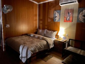 a bedroom with a bed and a night stand with a lamp at Mộc Homestay - Mộc Châu in Mộc Châu