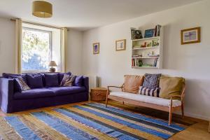 a living room with two purple couches and a rug at Maison Chalendeix in Nedde