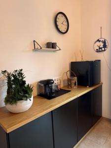 a counter with a microwave and a clock on the wall at Entre sabots et ronrons in Butten