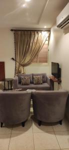 a living room with a couch and a television at عمارة النفيسة السكنية in Unayzah