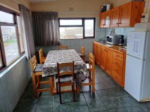 a kitchen with a table with chairs and a refrigerator at Gouritsmond Self Catering Units in Gouritzmond +72 photos