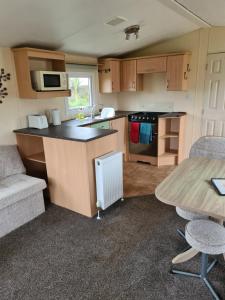 a small kitchen with a counter and a table at Fenlake holiday accommodation in Metheringham