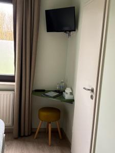 pokój z biurkiem, krzesłem i telewizorem w obiekcie Hotel en Bistro de Vaart w mieście Damme