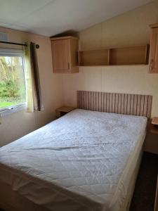 a bedroom with a large white bed with a window at Fenlake holiday accommodation in Metheringham