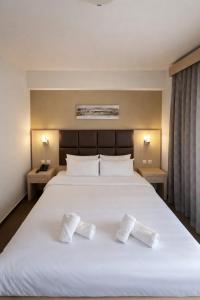 ein Schlafzimmer mit einem Bett, auf dem zwei weiße Socken liegen in der Unterkunft Thelxis in Volos