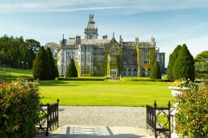 an old mansion with a grass field and trees at Manor Brook House in Adare