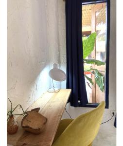 a table with a lamp and two yellow chairs at Triggerfish Hut at Casa Domingo in Ban Thong Phlu