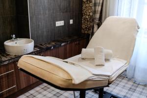a white chair in a bathroom with a sink at Pannonia 1893 Prémium in Sopron