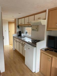 a small kitchen with white appliances and wooden cabinets at Houseboatvinkeveen Lelie in Vinkeveen +22 photos