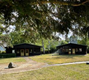 a large black building with a tree at HerbergeZumBrieselang in Brieselang
