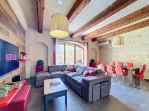 a living room with a couch and a table at Mia - Your Gozo Haven with Pool in Xagħra