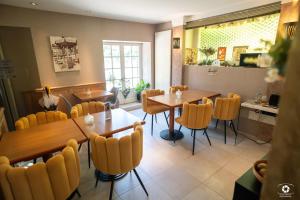 a restaurant with tables and chairs and a kitchen at La Petite Vernoelle in Prémilhat