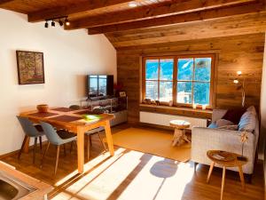 a living room with a dining room table and a television at Oswald Lodge - surrounded by nature in Sankt Oswald
