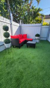 a garden with a red couch and a bench and a fence at Pop Art Loft in Hialeah