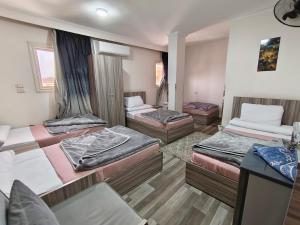 a room with four beds in it at فندق أجياد Agyad Hotel in Asyut