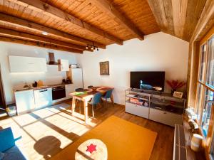a living room with a table and a kitchen at Oswald Lodge - surrounded by nature in Sankt Oswald +45 photos