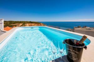 a swimming pool with a bottle of wine in a bucket at Penthouse Milhafre in Benagil