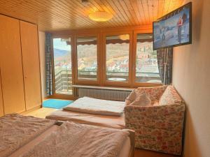 a room with two beds and a chair and a window at Steiert Panorama Apartments Todtnau in Todtnau