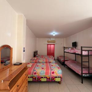 a bedroom with two beds and a desk at Casa de Huéspedes Playas Arena in Playas +76 photos