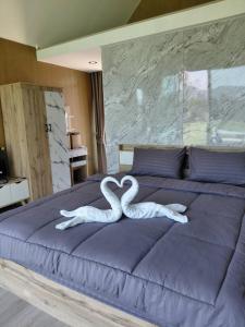 two white swans making a heart on a bed at ลึกลับรีสอร์ทบ้านนา in Nakhon Nayok