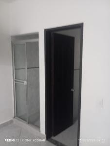 eine schwarze Tür in einem Raum mit einem Spiegel in der Unterkunft Hotel eden centro in Medellín