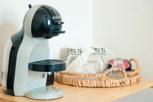 a coffee maker sitting next to a basket of glasses at Saludu Boutique in Porto Torres +34 photos