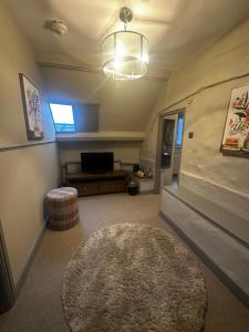 a living room with a large rug and a tv at The Ancient Gatehouse & Rugantino Restaurant in Wells