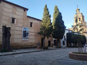 a building with two trees and a church at Suite Duquesa de Parcent in Ronda