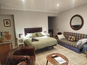 a bedroom with a bed and a couch at Suite Duquesa de Parcent in Ronda