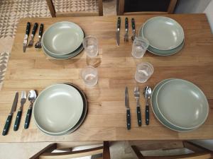 a wooden table with plates and silverware on it at Suite Duquesa de Parcent in Ronda