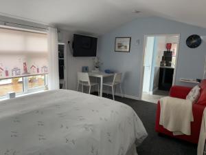 a bedroom with a bed and a table with chairs at The Garden Suite Holt in Holt