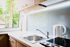 a kitchen with a sink and a window at LC pokoje & apartamenty in Pobierowo +119 photos