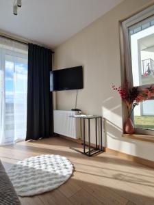a living room with a television and a table at Apartament Potockiego Private Parking Faktura in Rzeszów
