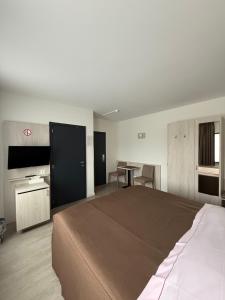a bedroom with a large bed and a table at Hotel Cleo in Kasterlee