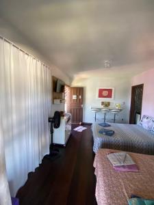 a hotel room with two beds and a desk at Residencial Rodrigues Florianópolis in Florianópolis