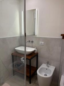 a bathroom with a sink and a toilet at Cozy Mountain Apartment with Cimone view in Faidello