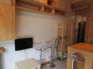 a room with two bar stools and a tv on a wall at Studette cosy 2 pers centre station La Mongie - FR-1-404-120 in La Mongie