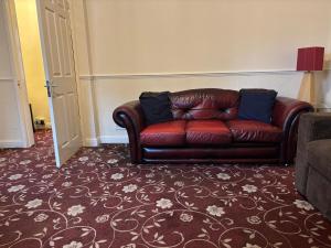 a brown leather couch sitting in a living room at Amazing Entire Home in WOLVERHAMPTON in Wolverhampton