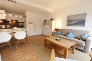 a living room with a couch and a table at MeerGlück in Langeoog