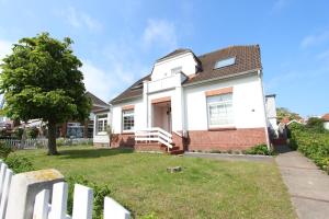 a white house with a tree in the yard at MeerGlück in Langeoog +9 photos