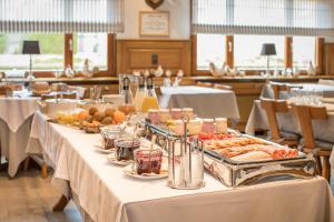 a long table with food on it in a restaurant at Logis Hôtel Restaurant & Spa au Soleil in Wettolsheim