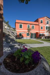 a building with a flower bed in front of it at Il Nuovo Vecchio Frantoio di Gardan Con Piscina in Vignana
