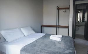 a white bed with two pillows on top of it at Innbox - Canasvieiras 2 in Florianópolis +12 photos