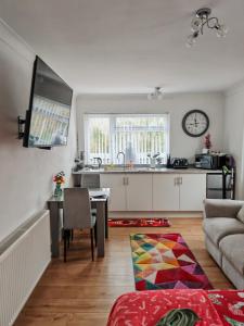 a kitchen and living room with a table and a couch at Pinecroft in Pembrokeshire