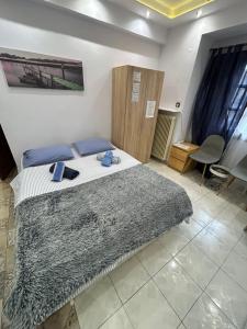 a bedroom with a bed with a blanket on it at Ano Poli Studios 1 in Thessaloniki
