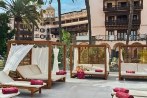a patio with chairs and hammocks in front of a building at Santa Catalina, a Royal Hideaway Hotel - Gran Lujo in Las Palmas de Gran Canaria +22 photos