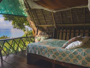 a bed in a room with a view of the ocean at Finca Exótica in Carate