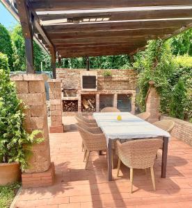 a patio with a table and chairs and a fireplace at Relax Holiday House in Balatonrendes