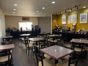 a restaurant with tables and chairs and a bar at Best Western Plus Battleground Inn & Suites in Battle Ground