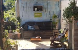 a living room with a couch in a patio at há uma bela casa in Ubatuba